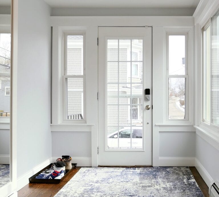 Bright front entry with glass door, sidelights, and shoe tray – modern home renovation in Beverly, Massachusetts